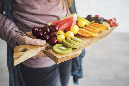Female hands holding assorted fruitsの写真素材