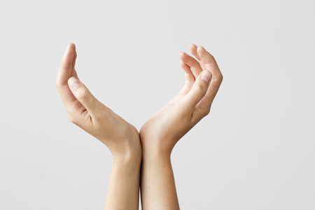 Cupped hands on gray backgroundの写真素材