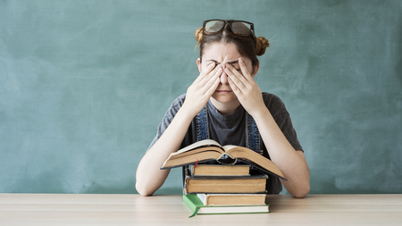 Tired young student girl with booksの写真素材