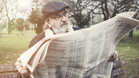 Old man reading newspaper in the parkの写真素材