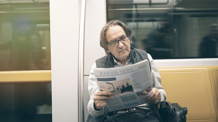 Man reading newspaper in the metro trainの写真素材