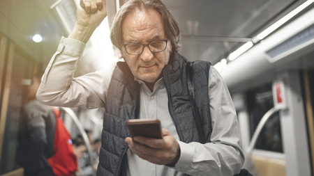 Man using mobile phone in the metro trainの写真素材