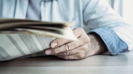 Businessman reading the newspaper on tableの写真素材