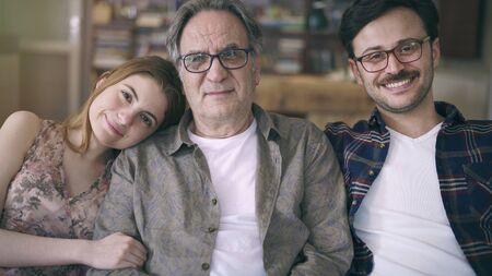 Young son and daughter embracing his father with loveの写真素材