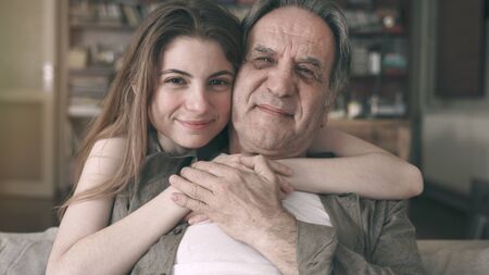 Cute young daughter embracing her father with loveの写真素材