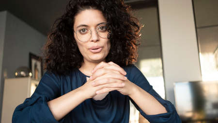 Young woman smiling and talking to webcamの写真素材