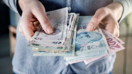 Hands are counting Turkish banknotes