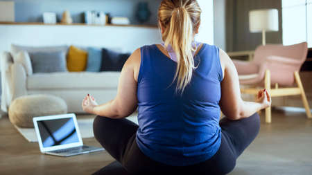 Young woman exercising yoga at home
