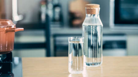 Glass of water and bottle on the kitchen tableの写真素材