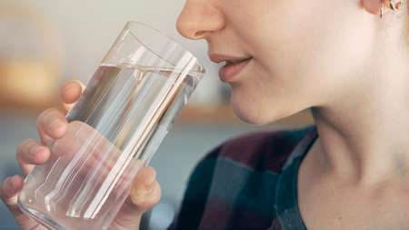 Young woman drinks a glass of water