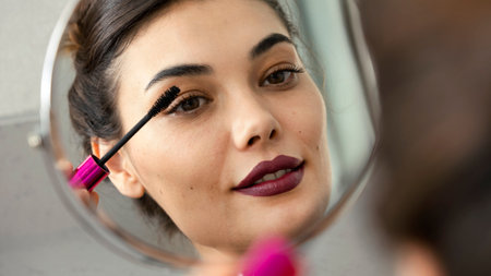 Woman applying black mascara on eyelashesの写真素材