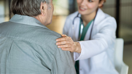 Doctor comforting patient by touching shoulderの写真素材