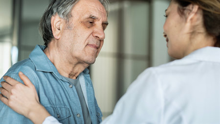 Doctor comforting patient by touching shoulderの写真素材