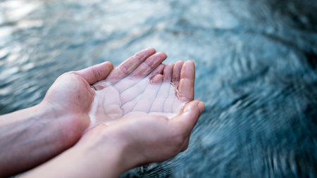 <p>A female hand touching the river water</p>の写真素材