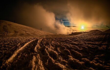 Sunset view from volcano Etna with snowy landscape and cloudy sky
