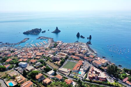 Acitrezza sea and village with stacks and Faraglioni cliff, Sicilyの写真素材