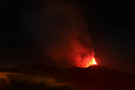 Etna eruption - explosion of lava from the crater night view in detail on the volcano Sicilyの写真素材