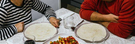 Unrecognizable couple eating vegetables at homeの写真素材
