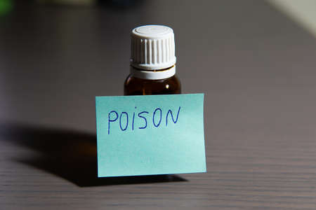 Container for medicinal liquid with white lid and brown glass labeled as poison.の写真素材