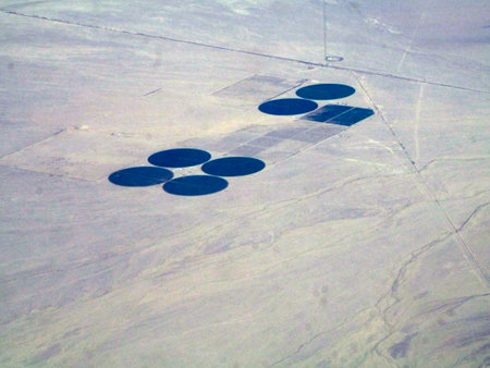 Expanding farming efforts in the southwest USA's deserts by tapping deep aquifers. These seven fields sit at the foothills of an Arizona mountain range, and seem to be spaced in such a way that will allow for more circle fields.の写真素材