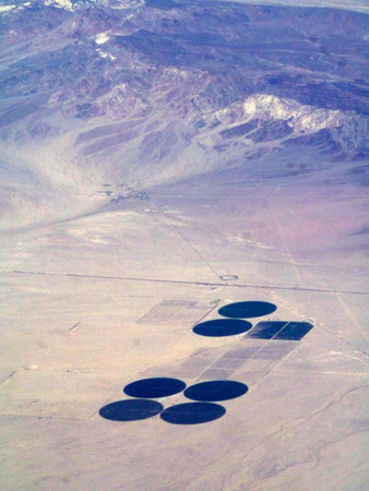 Expanding farming efforts in the southwest USA's deserts by tapping deep aquifers. These seven fields sit at the foothills of an Arizona mountain range, and seem to be spaced in such a way that will allow for more circle fields.の写真素材