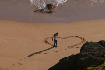 A person sprinted down the cliff and shuffled this heart into the sand. Then we watched the tide sweep it away. (Photo offered with his permission.)の写真素材