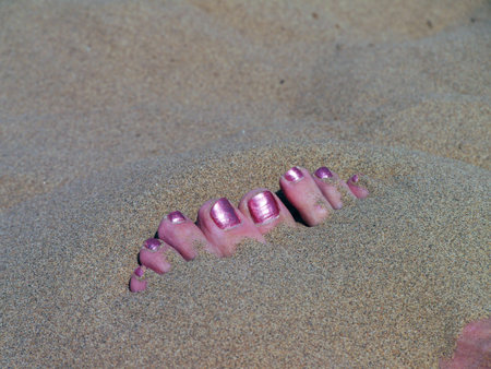 The sands of the Gobi Desert are blistering hot on the surface. Just a few inches below it's cool and refreshing. Bury your hands and feet to cool off, like this woman discovered. Western China, 2013の写真素材