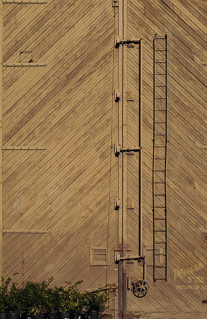 Have you ever seen a wood-slat door so giant it needs two-foot hinges and a two-story ladder just to lock it? Me neither.の写真素材
