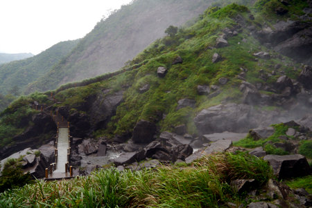 Even many locals don't know how to get to the Daixian Waterfall, I was told. Narrow and slick bridge over the rushing river gives way to an uphill climb. Lush greenery everywhere from the constant mist. Dehua, China 2015の写真素材