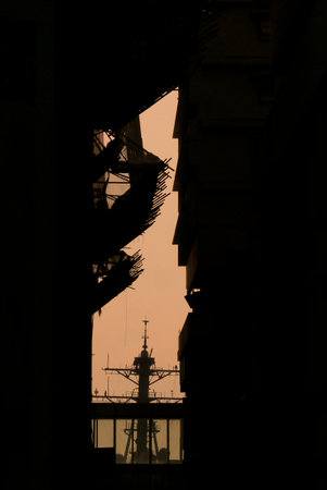 A peak between buildings yielded this view of a ship mast at sundown.の写真素材