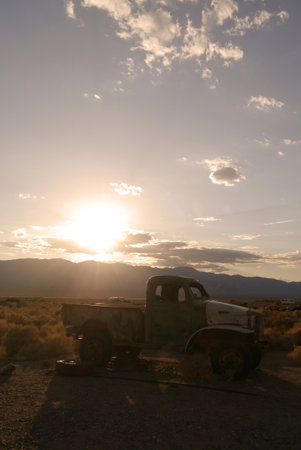 No branding in sight, just the sun setting for the thousandth time on an old pickup truck left in death valley for decades.のeditorial素材