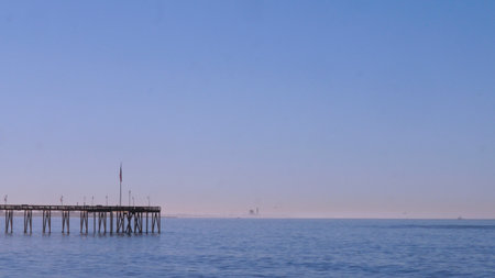 A windless morning at Ventura Beach, as the flag on the pier's end waits for a breeze on this fall morning. The haze will remain another hour or two.の写真素材