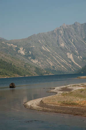 Sharp curve in lake through dry rocky mountainsの写真素材