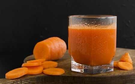 Freshly squeezed juice of carrots on black background
の写真素材