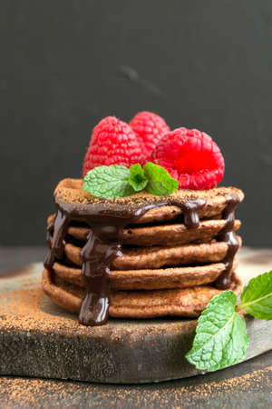 Chocolate pancakes with raspberry on a dark background.
の写真素材