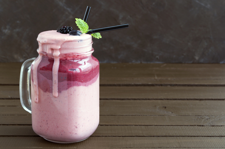 Milk shake in a jar on wooden background.の写真素材