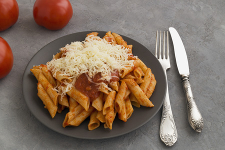 Penne pasta with tomato sauce on grey background.
の写真素材