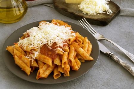 Penne pasta with tomato sauce on grey background.
の写真素材
