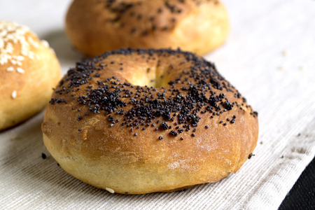 Bagel with poppy seeds on a light linen napkin.の写真素材