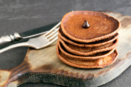 Chocolate pancakes with chocolate sauce on a dark background.