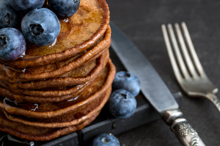 Chocolate pancakes with blueberries on a dark background.の写真素材