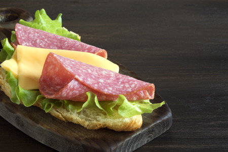 Croissant with sausage cheese and herbs. on dark backgroundの写真素材