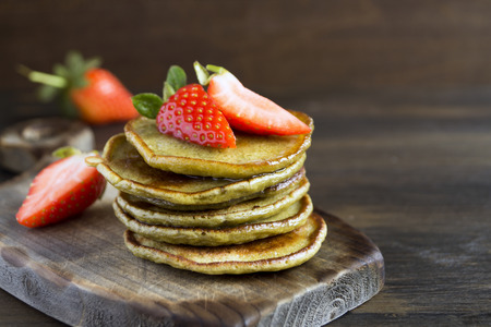 Vegetarian pancakes with ripe strawberries. on a wooden table.の写真素材