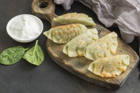 Vegetarian homemade dumplings with spinach on a dark background.の写真素材