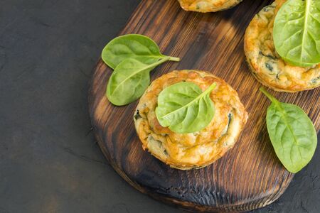 homemade cheese muffins with spinach. on dark background.の写真素材