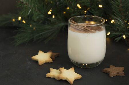 Cocktail eggnog and cookies are the stars on the background lights.の写真素材