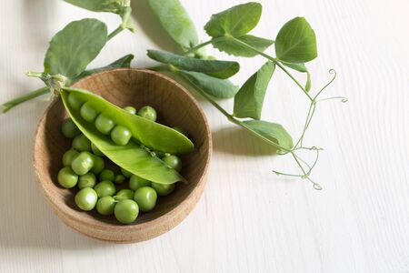 Young green peas on white wooden background.の写真素材