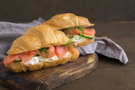 croissant with salmon and cream cheese on a wooden Board.

の写真素材