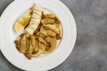 breakfast. pancakes with honey and nuts on a white plate.
の写真素材