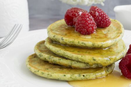 vegetarian spinach pancakes with raspberries and honey. homemade Breakfast.